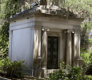 Un mausolée dans un cimetière en dessous un arbre